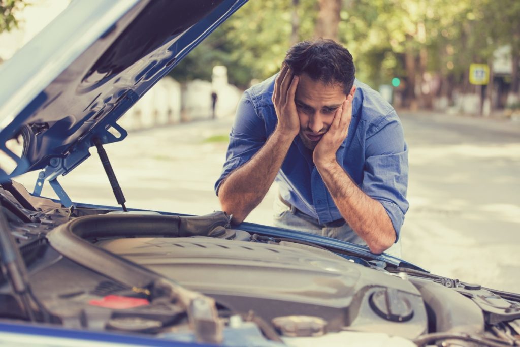 man frustrated at broken car